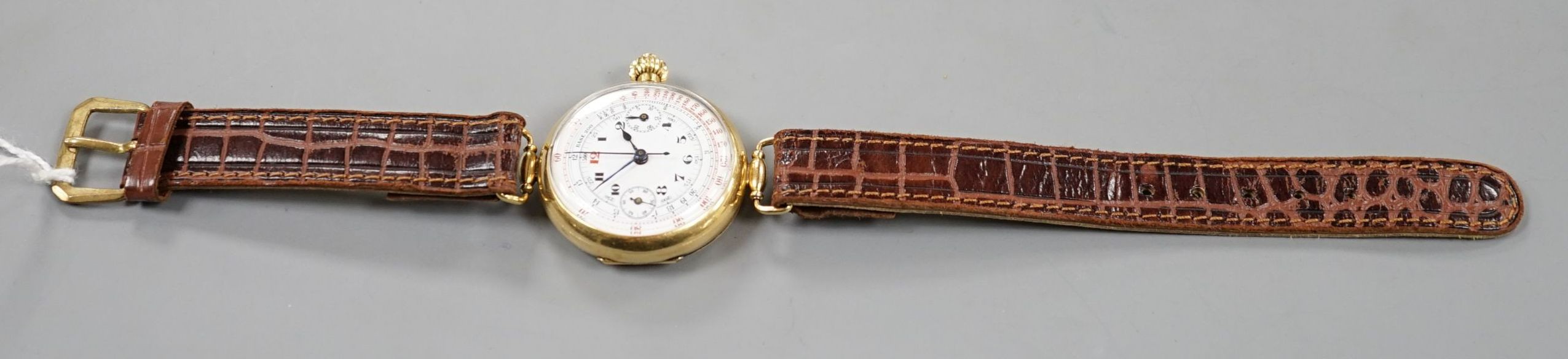 A gentleman's early 20th century 18k single button chronograph manual wind wrist watch, with enamelled Arabic dial and two subsidiary dials, with swivel lugs, on a later strap